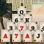 Stos kart w kształcie piramidy na tle z palmami i górami