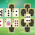 Karty do gry ułożone w układzie przypominającym piramidę na zielonym tle