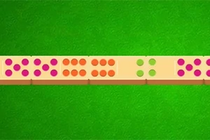 Różnokolorowe klocki z kropkami leżące na zielonym tle przypominającym stół do gry