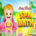 Dziecko z uśmiechem siedzące na fotelu w różowej sukience, z napisem Baby Hazel Spa Bath oraz dwoma obrazkami, jednym z plażą i morzem, drugim z wanną i łazienką w tle