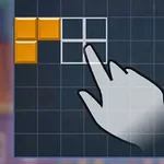 Ręka wskazuje na planszę z układem pomarańczowych klocków na niebieskim tle z siatką