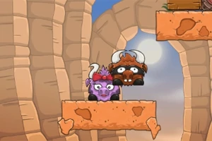 Dwa rysunkowe bizony o różnych kolorach stojące na skalnej platformie w kanionie