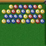 Kolorowe, ponumerowane kulki ułożone w rzędach na zielonym stole bilardowym