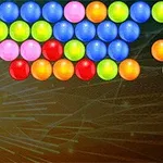 Kolorowe kulki ułożone w wiersze na tle ciemnego, wzorzystego tła