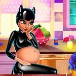 Kobieta w czarnym stroju z kocimi uszami siedzi przy stole, trzymając ciążowy brzuch, w kolorowej kuchni z kwiatami i świecami