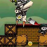 Postać w czarnym stroju z rakietą na tle skrzyń i worków z piaskiem, z maszyną przypominającą robota w lewym górnym rogu