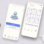 Dwa smartfony z aplikacją Sudoku na ekranach, otoczone zegarem, długopisami i rośliną