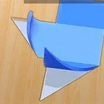 Papierowy kształt origami na drewnianej powierzchni składający się z niebieskich, białych i pomarańczowych elementów