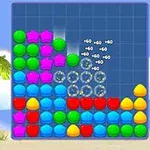 Kolorowe klocki w kształcie gwiazdek, kul i kwadratów ułożone na planszy z plażowym tłem, zawierające palmy i deski surfingowe