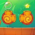 Zielony stworek siedzący na pomarańczowej platformie obok dwóch żółtych armat i unoszącej się bańki z dwoma gwiazdkami w tle