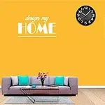 Kobieta wskazująca na wystrój pokoju z jasnożółtą ścianą, szarą sofą, poduszkami, zegarem i kwiatami