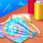 Koszulka w stylu tie-dye z kolorowym, spiralnym wzorem, znajdująca się na stole obok butelek z farbami