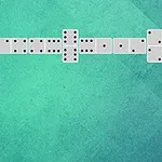 Ułożone pionki domina na zielonym tle w formie litery L