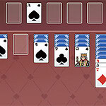 Układ kart na czerwonym tle, z kartami w rzędach i stosie bocznym