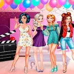 Cztery uśmiechnięte postacie kobiece w kolorowych strojach pozują w pomieszczeniu ozdobionym balonami i serpentynami, z klapsem filmowym i napisem #SELFIE na podłodze