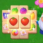 Krasnoludek w czerwonym kapeluszu stoi obok planszy z kolorowymi obrazkami owoców i kwiatów