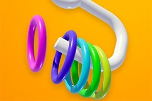 Kolorowe pierścienie zawieszone na białym, zakrzywionym pręcie na pomarańczowym tle