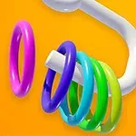 Kolorowe pierścienie zawieszone na białym, zakrzywionym pręcie na pomarańczowym tle