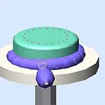 Fioletowy wałek dociskający się do turkusowego ciasta na dużym okrągłym stojaku