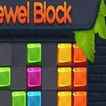 Kolorowe, błyszczące bloki ułożone na tle z ciemnych cegieł, z liśćmi na rogach i napisem Jewel Block na górze