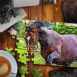 Puzzle przedstawiające galopującego konia w otoczeniu zieleni, ułożone na drewnianym stole obok filiżanki kawy