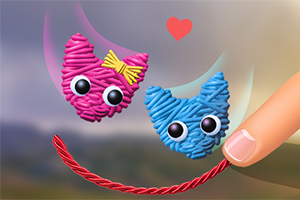Dwa urocze zwierzątka zrobione z włóczki, jedno różowe z kokardką, a drugie niebieskie, z dużymi oczami, oraz palec trzymający czerwoną nić i serce unosi się między nimi