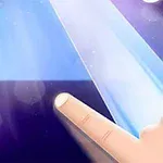 Palec dotykający czarny kwadrat na świecącej niebieskiej planszy z nutami w tle