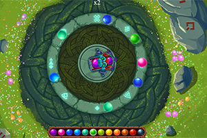 Kolorowe kulki ułożone w kręgu na tle z motywem kamiennym i trawiastym, z centralnie umieszczonymi symbolami i wzorami