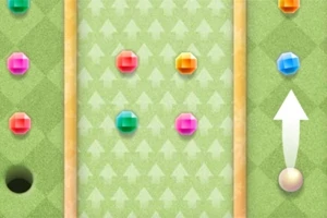 Zielona plansza z kolorowymi kulkami i strzałką wskazującą kierunek