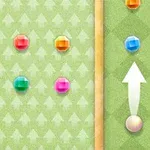 Zielona plansza z kolorowymi kulkami i strzałką wskazującą kierunek