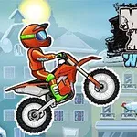 Motocyklista w pomarańczowym stroju jadący na motorze zimą, obok ozdobionej choinki, na tle zaśnieżonych budynków