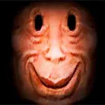 Twarz o ciemnych oczodołach i szerokim uśmiechu na czerwonawym tle