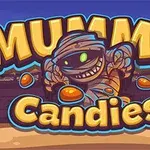 Mumia z zielonymi oczami i szerokim uśmiechem otoczona cukierkami z napisem Mummy Candies na tle egipskiej scenerii