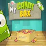 Zielony, uśmiechnięty żelkowy stworek obok kartonowego pudełka z cukierkami i kolorowym napisem My Candy Box