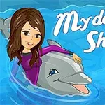 Kobieta z długimi brązowymi włosami siedzi na delfinie w błękitnej wodzie, obok napis My dolphin Show