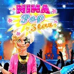 Postać w jaskrawym stroju na scenie z kolorowymi światłami i płomieniami w tle, z uniesionymi rękami publiczności