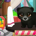 Mały czarny miś stoi na stole w bajkowym wnętrzu z zielonymi drzewami w tle