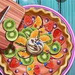 Tarta z różnorodnymi owocami, takimi jak kiwi, pomarańcze i truskawki, ozdobiona bitą śmietaną i kolorowymi dekoracjami na talerzu, z deseczką do krojenia i nożem po lewej stronie