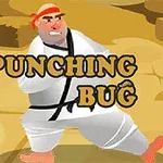 Mężczyzna w białym kimonie z czarnym pasem i czerwoną opaską stoi na pustynnym tle z napisem PUNCHING BUG