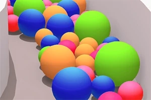 Kolorowe kule różnej wielkości toczące się w wąskim kanale