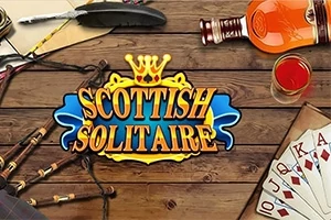 Karty do gry, szkocki kilt, butelka whisky, pióro i szkło na drewnianym stole