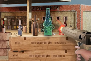 Osoba trzymająca pistolet strzela do butelek ustawionych na drewnianej skrzyni na tle pustynnego miasteczka