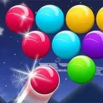 Kolorowe kulki na tle nocnego nieba z gwiazdami, z wyróżnioną jasną kulką przygotowaną do wystrzału