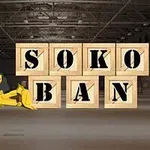 Żółta koparka przed sześcioma drewnianymi skrzyniami z napisem SOKOBAN w magazynie