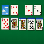 Zielony stolik z rozłożonymi kartami do gry, w tym asy, króle, damy i karty z cyframi