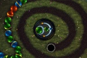 Kolorowe kulki ułożone w spiralny tor na zielonym tle z ciemnym środkiem i otworem