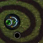 Kolorowe kulki ułożone w spiralny tor na zielonym tle z ciemnym środkiem i otworem