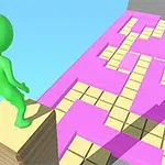 Zielona postać stojąca na stosie desek nad różowo-żółtą platformą z geometrycznymi wzorami