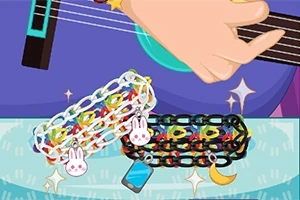 Ręka grająca na gitarze z kolorowymi bransoletkami z zawieszkami w kształcie królika, księżyca i telefonu