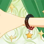 Dłoń ozdobiona bransoletką z gwiazdką na tle zielonych zasłon i wirującego wzoru